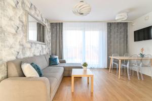 グディニャにあるLTC Apartments Ujejskiegoのソファとテーブルのあるリビングルーム
