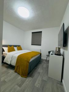 um quarto com uma cama e uma televisão de ecrã plano em Ensuite Luxury Bedroom In Purfleet em Purfleet
