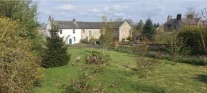 a large white house with a garden in front of it at Molly The Vintage Caravan. in Wigton +11 photos