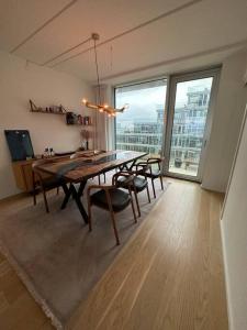 een eetkamer met een tafel en stoelen en een groot raam bij AArhus 115 in Aarhus