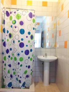 a bathroom with a shower curtain and a sink at O Sardinhas in Matosinhos