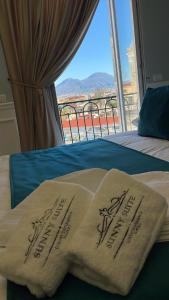 un letto con due asciugamani da sposa e vista di Sunny Suite Napoli a Napoli