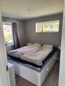 een bed in een kleine kamer met een raam bij Tångaberg, Varberg in Varberg