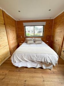 1 dormitorio con 1 cama grande y ventana en Refugio Lobos en Pichilemu