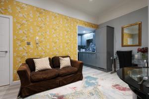 uma sala de estar com um sofá e uma parede amarela em Durley Gardens, by the Beach em Bournemouth