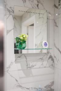 a bathroom with a mirror and a vase with flowers at Durley Gardens, by the Beach in Bournemouth