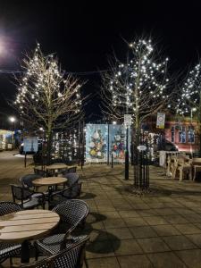 an outdoor patio with tables and trees with lights at The Snug Lytham in Lytham St Annes