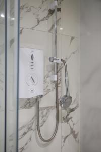 a shower with a shower head in a bathroom at Durley Gardens, by the Beach in Bournemouth