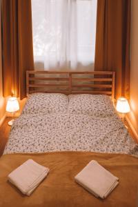 1 cama con 2 toallas y ventana en Apartament 3, en Polanica-Zdrój