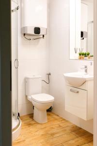 a white bathroom with a toilet and a sink at Apartament 3 in Polanica-Zdrój