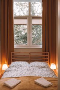 a bedroom with a bed with a large window at Apartament 3 in Polanica-Zdrój