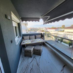 a balcony with a couch and a table on a balcony at Luksuzni Apartman Harmonija Paralija in Paralia Katerinis