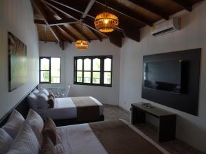 um quarto com uma cama e uma televisão de ecrã plano em Hotel Palmas De Alcalá em Playa Verde
