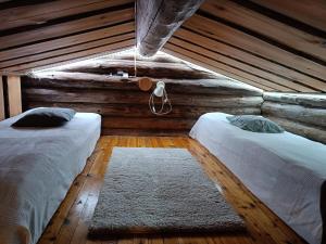 SyöteにあるMäntyharju-mökkiのベッド2台 木製の壁の部屋