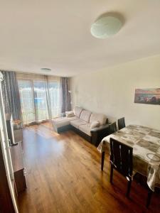 un soggiorno con un divano e un tavolo di Diamond Beach Garden Apartment a Burgas