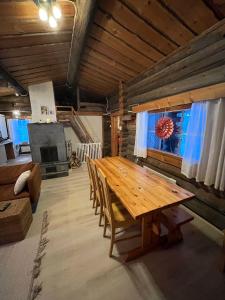 索特的住宿－Mäntyharju-mökki，一张木桌和椅子,位于一个配有沙发的房间