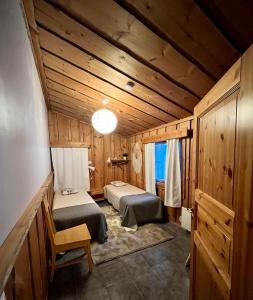 SyöteにあるMäntyharju-mökkiのベッド2台 木製の壁の部屋
