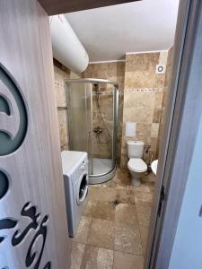 un bagno con wc e doccia in vetro di Diamond Beach Garden Apartment a Burgas