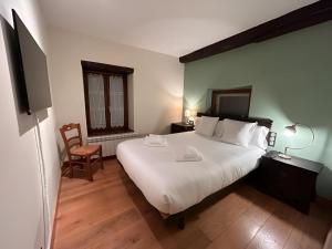 a bedroom with a large white bed and a chair at Apto ElizaG-1 in Lesaka