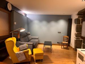a living room with a couch and yellow chairs at Apto ElizaG-1 in Lesaka