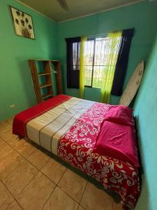 - une chambre avec un lit et une planche de surf dans l'établissement Surf House, à Sámara