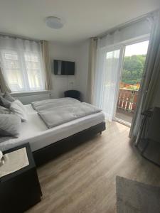 a bedroom with a bed and a large window at Gästehaus und Ferienwohnung Bächle in Bad Peterstal