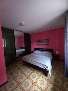 um quarto com uma cama grande numa parede vermelha em Casa vacanza Sunflower em Ponte Caffaro