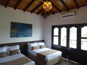 Playa Verde的住宿－Hotel Palmas De Alcalá，一间卧室配有两张床和吊灯。