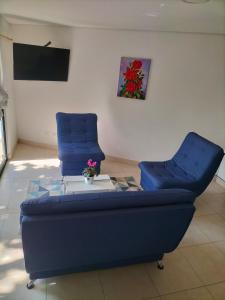 a living room with a blue couch and a glass table at Casa del Arbol Apto. 301 in Medellín