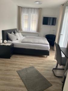 Schlafzimmer mit einem Bett, einem Schreibtisch und einem TV in der Unterkunft Gästehaus und Ferienwohnung Bächle in Bad Peterstal