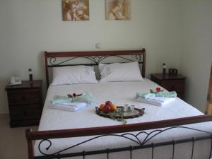 Una cama con una bandeja de fruta. en ANEMOESSA APTS en Livadia