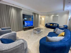 uma sala de estar com dois sofás azuis e uma televisão em ملك فيلا em Medina