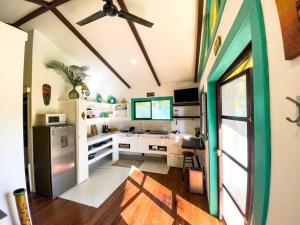a kitchen with white cabinets and a green door at Casita Kreyol Jungle Sanctuary/Walk to Playa Negra in Hone Creek