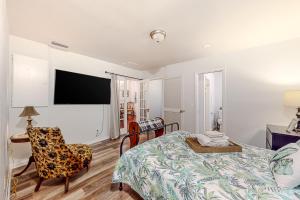 1 dormitorio con 1 cama y TV en la pared en Oak Street Bungalow en Arcadia