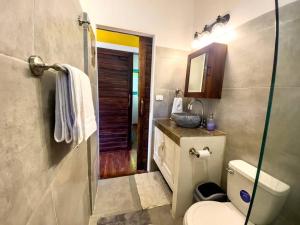 a bathroom with a toilet and a sink and a shower at Casita Kreyol Jungle Sanctuary/Walk to Playa Negra in Hone Creek