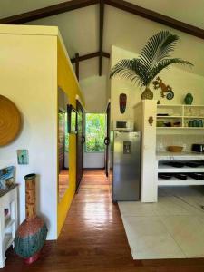 a kitchen with a refrigerator and a palm tree in it at Casita Kreyol Jungle Sanctuary/Walk to Playa Negra in Hone Creek