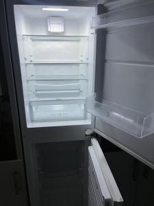 an empty refrigerator with its door open in a kitchen at High Street Lodge in Clowne