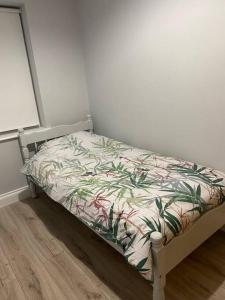 Una cama en una habitación con una colcha con plantas. en Modern 3 bed country cottage, 
