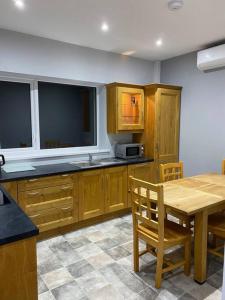 una cocina con armarios de madera y una mesa de madera con un asterisco en Modern 3 bed country cottage 