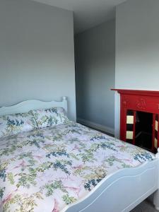 1 dormitorio con cama y mesa roja en Modern 3 bed country cottage 