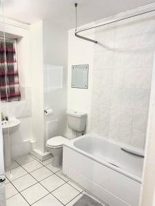 a white bathroom with a toilet and a bath tub at londesborough inn in London