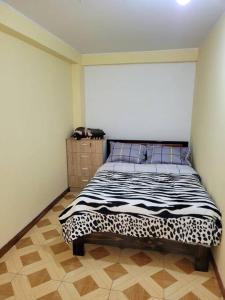 a bedroom with a bed with a black and white blanket at Apartamento en Huancayo in Huancayo
