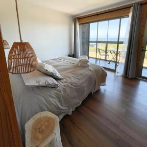 a bedroom with a bed with a view of the ocean at Refugio Lobos in Pichilemu
