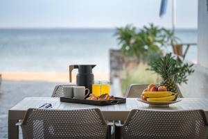 - une table avec une assiette de fruits sur une table avec la plage dans l'établissement Bluetique Seaside Suites, à Gra Liyiá