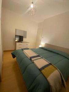 een slaapkamer met een groen bed en een televisie bij Appartamento in centro storico ad uso esclusivo self check-in H24 in Foligno