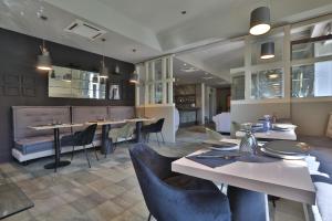 a dining room with tables and chairs in a restaurant at Hotel Le Corderie in Trieste