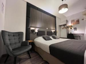 a hotel room with a bed and a chair at Le Cheval Blanc, Cognac Centre in Cognac