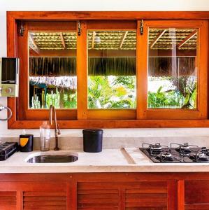 um balcão de cozinha com um lavatório e uma janela em Casa Bora Lá em Caraíva