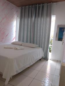 - une chambre avec un lit blanc et une fenêtre dans l'établissement Pousada Shamah, à Morro de São Paulo