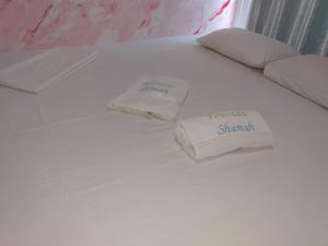 Una cama blanca con dos toallas encima. en Pousada Shamah en Morro de São Paulo